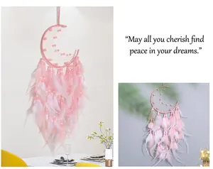 Detailed view of handmade pink moon dreamcatcher with feathers and beads decor