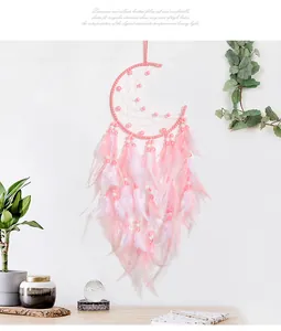 Detail of pink moon dreamcatcher featuring delicate feathers and decorative beads