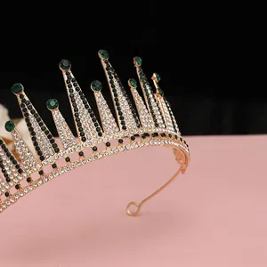 Dettaglio ravvicinato della corona da sposa dorata con cristalli verdi e strass