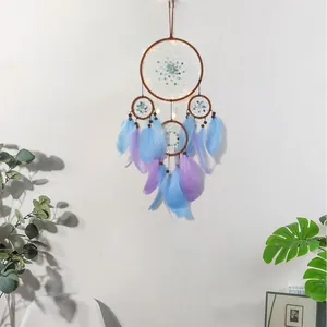 Acchiappasogni blu e viola con piume e luci LED su una decorazione murale bianca