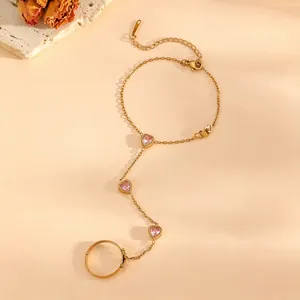 Macro detail of 18k gold slave bracelet with pink heart stones and lobster clasp