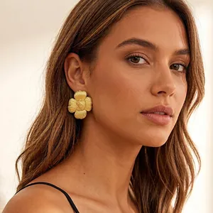 Boucles d'oreilles tournesol vintage plaquées or pour femmes portées par un modèle
