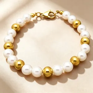 Detailed shot of 8mm cream pearls and polished gold beads on a minimalist bracelet