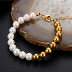 Detailed shot of half-pearl and golden bead bracelet on a natural agate stone