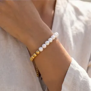 Detail of elegant pearl and gold bead bracelet with adjustable chain on wrist