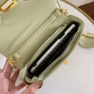 Close-up of the light green quilted crossbody bag showing internal space and zipper pocket