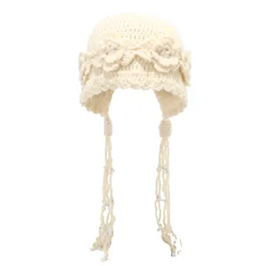 Handmade crochet knit beanie in off-white with floral accents and beaded tassel ties