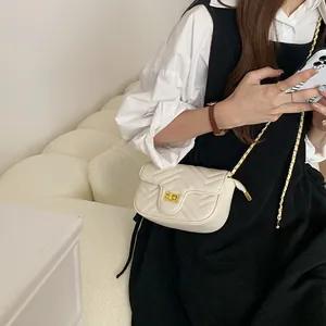 Close-up of the ivory quilted leather crossbody bag with golden chain and metal lock