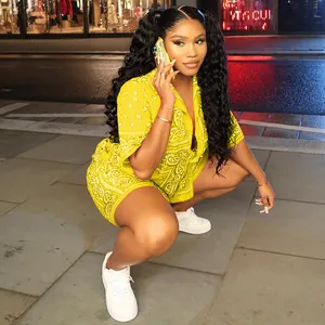 Detail of yellow paisley print shirt and shorts set on model in urban night setting