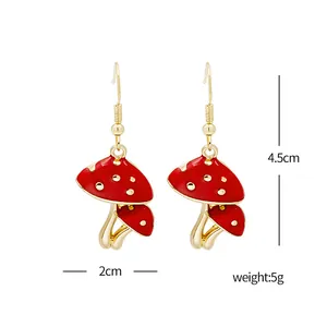 Detailed view of red mushroom earrings with gold hooks measuring 4.5cm by 2cm in size