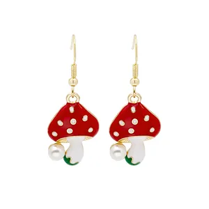 Cute red mushroom drop earrings with white pearls and gold hooks on white background