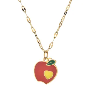 Detail of apple pendant necklace with red enamel finish and small yellow heart