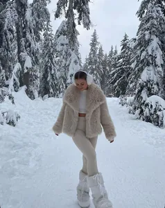 Dettaglio della giacca in ecopelliccia beige chiaro con ampio collo nella neve