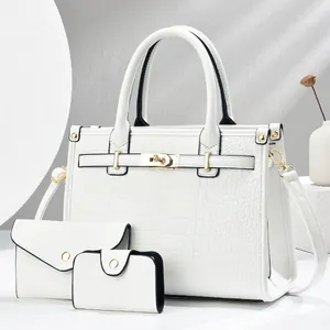 Detailed view of white crocodile pattern three-piece bag set with golden hardware