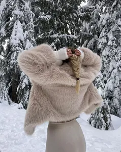 Vista posteriore di un cappotto in ecopelliccia beige soffice in un bosco innevato