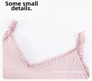 Detail of V-neckline with fringe trim on a pink cotton pajama dress showing fabric texture