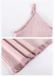 Detail of light pink cotton sleepwear with vertical pleats and fringe trim edges