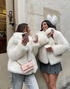Dettaglio della consistenza del cappotto in ecopelliccia bianca con maniche lunghe