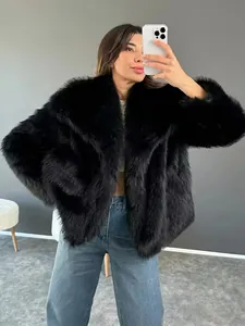 Giacca corta in ecopelliccia nera da donna con jeans blu in un selfie allo specchio