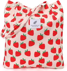 Detail of strawberry corduroy tote bag with embroidered label and soft texture