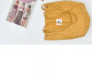 Detail of mustard yellow corduroy tote bag showing textured fabric and metal fastener