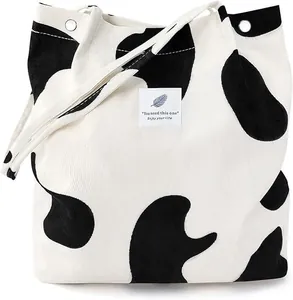 Corduroy tote bag with black and white cow pattern and decorative slogan patch
