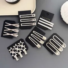 Detail view of various silver geometric minimalist hair clips in star and bar designs
