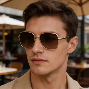 Gros plan de lunettes de soleil carrées pour hommes avec monture en métal doré.