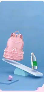 Ultra-light pink girls' backpack with lace ruffles weighing 290g balanced on a seesaw