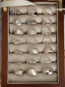 Macro view of vintage S925 sterling silver rings in a wooden jewelry display box