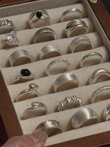 Collection of vintage S925 sterling silver rings displayed in a wooden jewelry box.