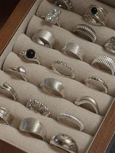 Vintage S925 sterling silver rings collection displayed in a wooden jewelry box.