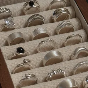 Vintage S925 sterling silver ring collection displayed in a beige jewelry box.