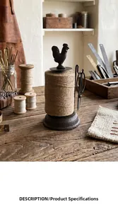 Detailed view of a vintage cast iron rooster twine holder with scissors on a rustic wood table