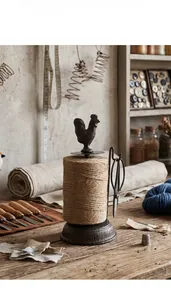 Vintage cast iron rooster twine holder with scissors in a rustic workshop setting