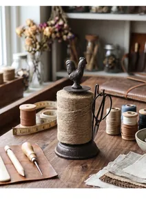 Detailed view of a vintage cast iron twine holder with a rooster motif and jute twine.