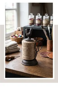 Close-up of vintage cast iron rooster twine holder with scissors on wooden table