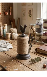 Detailed macro view of vintage cast iron rooster twine holder with antique scissors