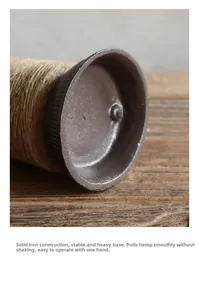 Detailed macro view showing the solid cast iron base of a vintage twine dispenser