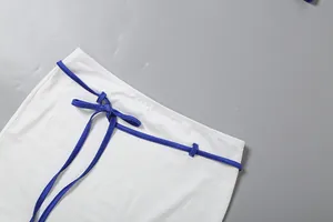 Vue détaillée de la ceinture bleue élégante sur une jupe blanche moulante et sexy