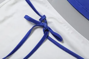 Gros plan sur le nœud bleu de l'ensemble jupe sexy blanc en deux pièces pour femme