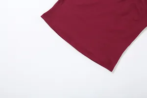 Gros plan montrant l'ourlet à double couture précise d'une mini-jupe de couleur rouge vin