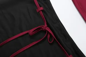 Vue détaillée d'une robe noire moulante avec un élégant lien bordeaux sur le côté