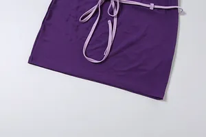 Détail d'une mini-jupe moulante violette avec une ceinture de couleur lavande claire