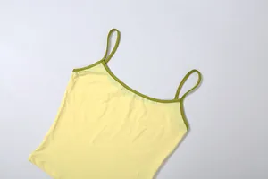 Gros plan d'un caraco jaune avec bordure verte montrant les bretelles et l'encolure