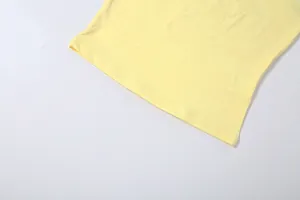 Gros plan de l'ourlet à double couture sur un vêtement en tissu extensible jaune clair.