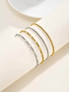 Vue détaillée de quatre bracelets à maillons en acier inoxydable empilés, or et argent