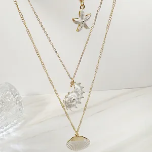 Detail der böhmischen Mehrfachkette mit weißen Seestern- und Muschelanhängern in Gold