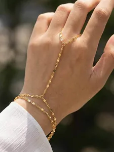 Detail view of a dainty gold-plated stainless steel hand chain bracelet worn on hand
