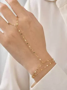 Detailed view of a gold-tone stainless steel lip chain finger bracelet on hand